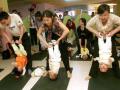Chinese parents perform stretching exercises with their babies at a center in Xiamen, in southeast China's Fujian province, 01 April 2007, designed to improve the babies' alertness and balance. China's government has long viewed its population of 1.3 billion people, the world's largest, as the greatest challenge to the nation's modernisation, vowing to continue the nearly 30-year-old policy beyond 2033, when China's population is expected to peak at 1.5 billion people.     CHINA OUT GETTY OUT          AFP PHOTO (Photo by AFP / AFP)