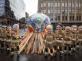 Un grupo de activistas mientras posan como líderes mundiales disfrazados de bomberos este viernes durante el último día de la COP26