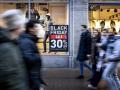 Viandantes pasan delante de un establecimiento con ofertas de Black Friday en Ámsterdam