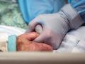 Una enfermera coge la mano de una paciente con coronavirus que está ingresada en la UCI del Hospital de Sharp Grossmont en La Mesa, San Diego, California, Estados Unidos