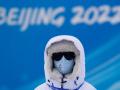 Un voluntario se protege del frío en el parque de nieve Genting, cerca de la sede de los Juegos Olímpicos de Invierno Pekín 2022