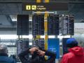 Varias personas observan los paneles de llegadas en el aeropuerto de Adolfo Suárez