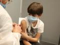 Enfermera vacunando a un niño menor de once años