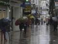 Transeúntes caminando por la calle Real de La Coruña un día de lluvia