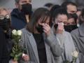 Los familiares de los marineros, rotos en dolor depositando rosas blancas tras la ceremonia