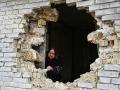 Una mujer ucraniana se asoma al boquete provocado por los ataques de Rusia en la pared de su casa