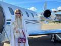 Una joven rusa frente a un jet privado, con su bolso de Dior