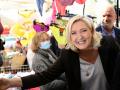 French far-right party Rassemblement National (RN) presidential candidate Marine Le Pen (R)  shakes hands with a supporter during a campaign visit at Pertuis' market, South of France, on April 15, 2022. - Marine Le Pen will face French President and liberal party La Republique en Marche (LREM) candidate for re-election Emmanuel Macron in a run-off vote on April 24, 2022, after first round voting on April 10. (Photo by CHRISTOPHE SIMON / AFP)
