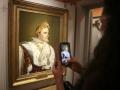 Una mujer saca una fotografía de uno de los cuadros más famosos de Napoleón Bonaparte en una exposición dedicada al emperador francés en su casa natal