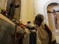 Una mujer cubana pone una vela ante la imagen de san Francisco de Asís, en una iglesia de La Habana
