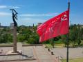 Una réplica de la bandera soviética de la victoria vuela junto a un monumento conmemorativo de la Segunda Guerra Mundial en la ciudad de Jersón el 20 de mayo de 2022, en medio de la acción militar rusa en curso en Ucrania