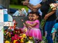 Una mujer deposita flores junto a su hija en un monolito improvisado en Uvalde, Texas, donde se produjo la masacre en un colegio
