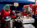 Volunteers from Caritas Poland serve hot soup for refugees on a camp in the commercial area fn Przemysl, southwestern Poland, on March 1, 2022.