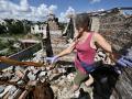 Una mujer frente a los escombros de la ciudad de Mala Rogan, su hogar