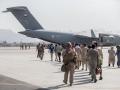 Evacuees load on to a U.S. Air Force Boeing C-17 Globemaster III during an evacuation at Hamid Karzai International Airport, Kabul, Afghanistan, August 21, 2021.