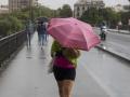 Varias personas se refugian en sus paraguas por la lluvia