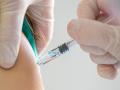 Una enfermera administra una dosis de vacuna de la gripe