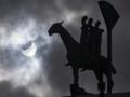 Un eclipse solar parcial se ve detrás de la estatua 'Jinete del Apocalipsis' del artista Bjorn Norgaard en el centro de Malmo, Suecia