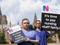 Personal de enfermería sujetan pancartas en el exterior del Real Colegio de Enfermería británico en Londres
