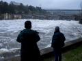 Dos hombres observan la fuerza del Miño a su paso por el embalse de Velle, en Orense