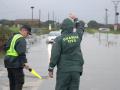 Dos Guardias civiles tratan de impedir que un Seat Ibiza quede atascado en una balsa de agua