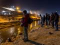 Inmigrantes hispanos a la orilla del Río Bravo esperando cruzar hacia El Paso, Texas