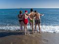 Unos jóvenes se bañan en la playa de la Barceloneta, a 25 de diciembre de 2022, en Barcelona