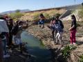 Migrants cross the Bravo river seen from the Mexican side of the US-Mexico border in Ciudad Juarez, Chihuahua state, Mexico, on March 29, 2023. - About 200,000 people try to cross the border from Mexico into the United States each month, most of them fleeing poverty and violence in Central and South America. (Photo by Guillermo Arias / AFP)