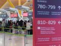 Varias personas esperan para embarcar y facturar en la zona de salidasTerminal 4 del Aeropuerto Adolfo Suárez Madrid-Barajas