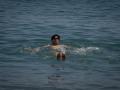 Un hombre se da un baño en la playa de la Barceloneta