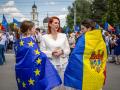 La ministra del Interior de Moldavia (Centro) junto a dos jóvenes con las banderas de la UE y de Moldavia