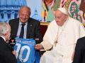 Owner of SSC Napoli football club, Aurelio De Laurentiis (L) speaks to Pope Francis (R) as co-Director of the NGO Scholas Occurentes Jose Maria del Corral (C) looks on, after De Laurentiis presented the Pope with a jersey of SSC Napoli flocked with his name, during the "Eco-Educational Cities" conference organised by Scholas Ocurrentes and aimed at promoting education and sustainability on May 25, 2023 at the Augustinian Patristic Pontifical Institute in Rome. (Photo by Andreas SOLARO / AFP)