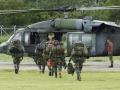 Los soldados abordan un helicóptero que se dirige a la zona de búsqueda de los menores perdidos en Colombia