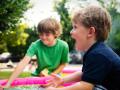 Dos niños juegan en el parque con agua