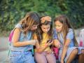 Tres niñas mirando la pantalla del móvil