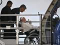 Pope Francis, seated on a wheelchair, is lifted on a platform to board his plane on August 2, 2023 at Rome's Fiumicino airport, heading to the World Youth Day in Lisbon where a million youngsters from across the world are expected. (Photo by Andreas SOLARO / AFP)