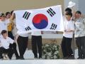 Pilgrims celebrate on stage holding a South Korean flag, as the next WYD are to be held in Seoul, during the closing mass of the World Youth Days (WYD) in Tejo Park, Lisbon, on August 6, 2023. Around one million pilgrims from all over the world will attend the World Youth Day, the largest Catholic gathering in the world, created in 1986 by John Paul II. (Photo by Thomas COEX / AFP)