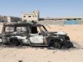 Los restos de un automóvil quemado tras dos días de enfrentamientos mortales entre dos grupos rivales en la capital de Libia