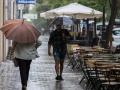 Varias personas se resguardan de la lluvia con paraguas