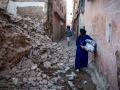 Una mujer mira los escombros de un edificio en la antigua ciudad de Marrakech