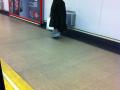 Pobre calzado con bolsas en los pies en el Metro