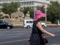 Una mujer pasea por una calle de Madrid con sombrero en pleno episodio de calor