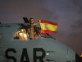 Un militar ondea la bandera española desde el avión del Destacamento Orión