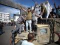 Palestinos sobre un jeep militar israelí por las calles de Gaza.