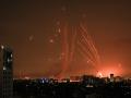 A salvo of rockets is fired by Palestinian militants from Gaza as an Israeli missile launched from the Iron Dome defence missile system attempts to intercept the rockets, fired from the Gaza Strip, over the city of Netivot in southern Israel on October 8, 2023. - Israel, reeling from the deadliest attack on its territory in half a century, formally declared war on Hamas Sunday as the conflict's death toll surged close to 1,000 after the Palestinian militant group launched a massive surprise assault from Gaza. (Photo by MAHMUD HAMS / AFP)