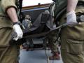 Soldados israelíes llevan los cuerpos de los israelíes asesinados en el kibutz de Kfar Aza, cerca de la frontera con Gaza