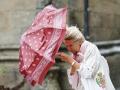 Una mujer se protege del viento y la lluvia, este martes en la plaza del Obradoiro de Santiago de Compostela