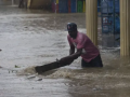 Un residente retira los restos en una calle inundada debido al paso de la tormenta tropical