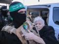 Un brigadista de  Al-Qassam libera a una de las rehenes israelías