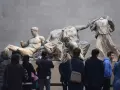 Varios visitantes observan las esculturas de la colección Mármoles de Elgin en el Museo Británico